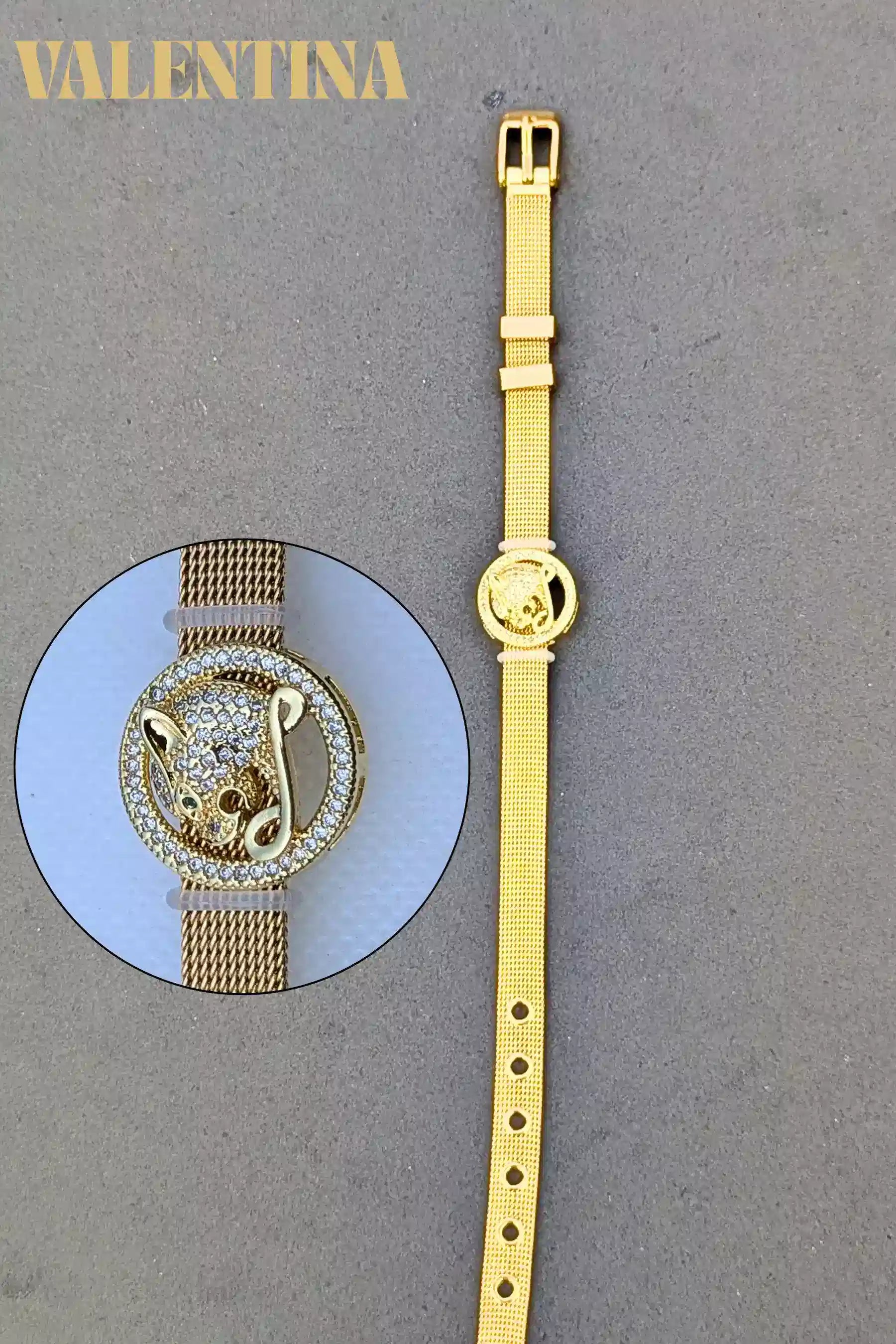 Gold bracelet with a close-up detail on a gray background, featuring the brand 'Valentina'.