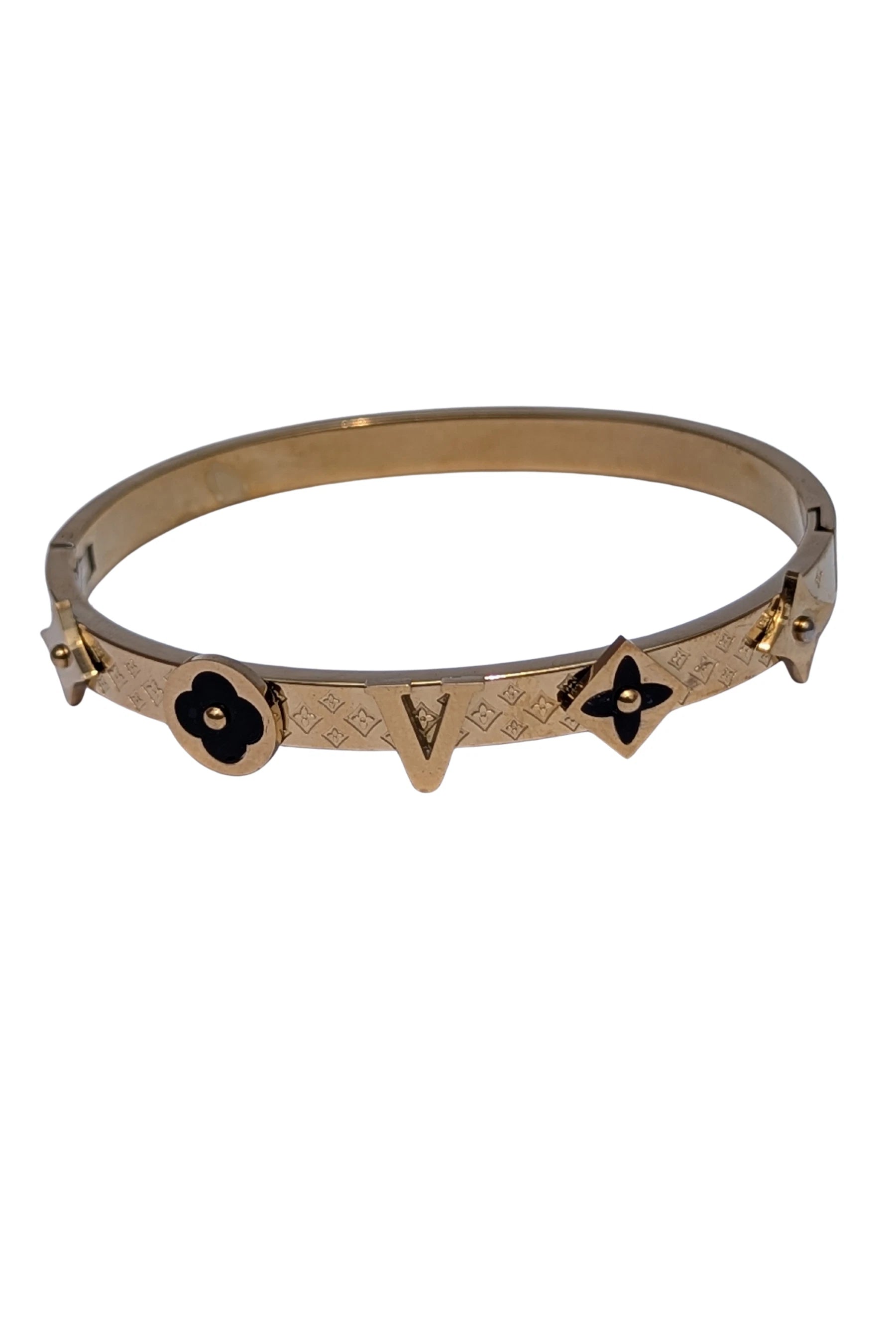 Gold bracelet with black floral designs on a white background
