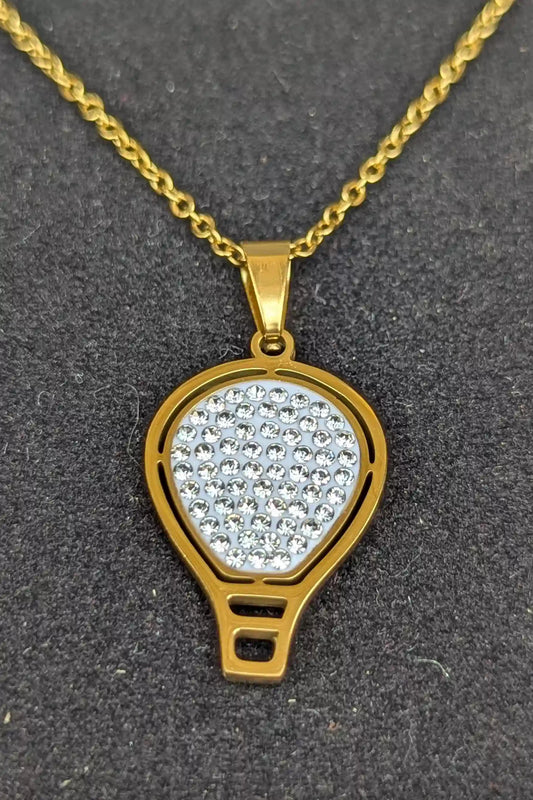 Gold necklace with a diamond-encrusted pendant on a dark background