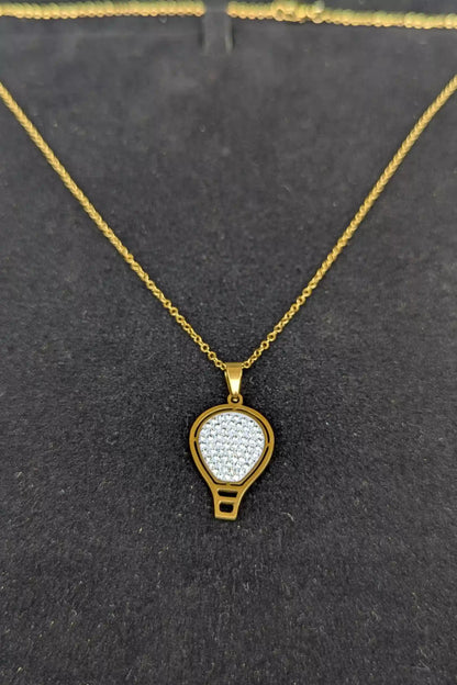 Gold necklace with a pendant on a black background