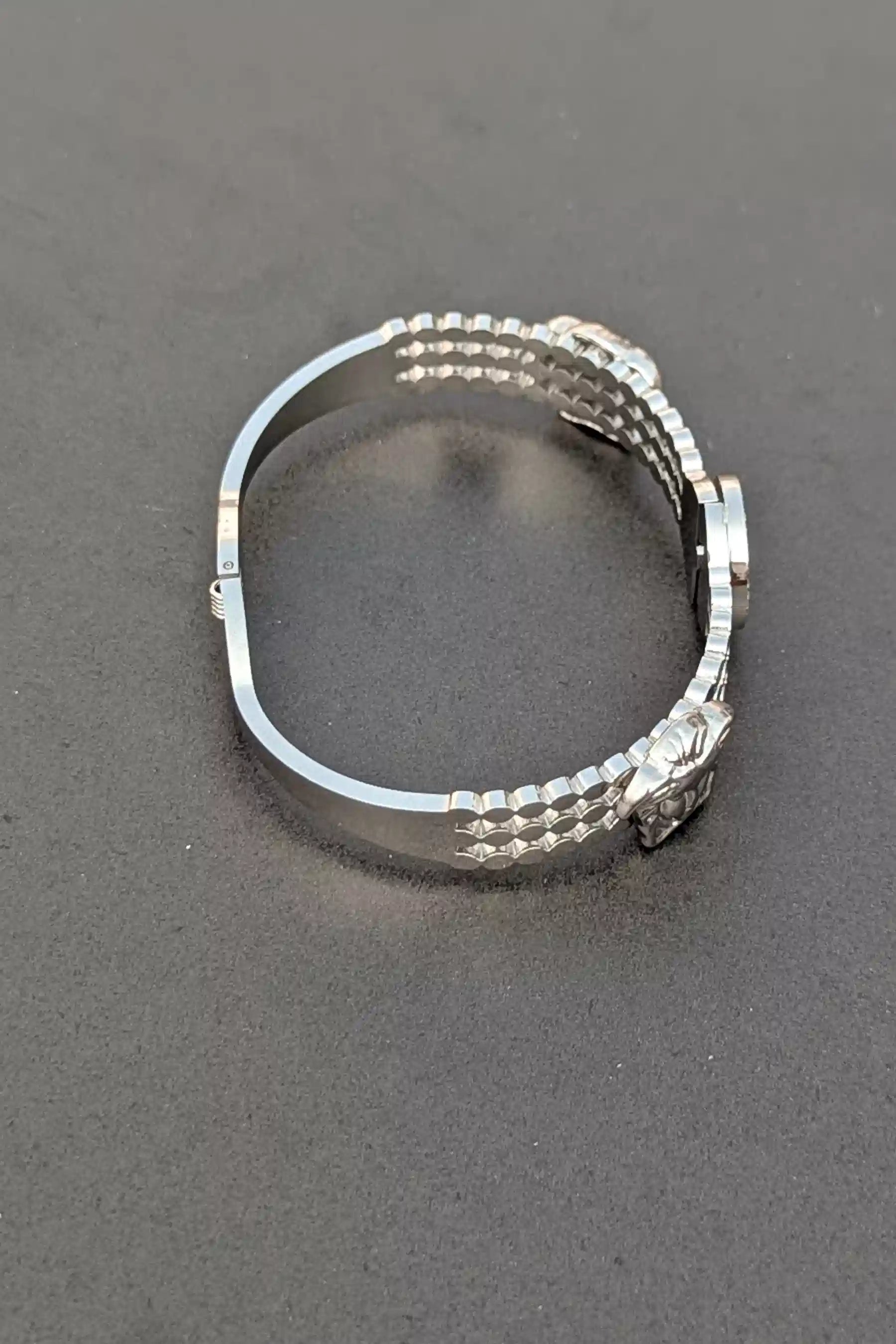 Silver ring with a textured band on a gray background