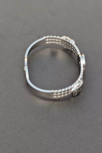 Silver ring with a textured band on a gray background