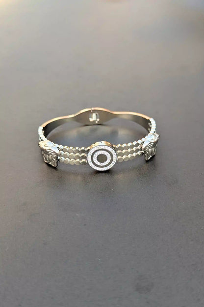 Silver bracelet with decorative elements on a dark surface
