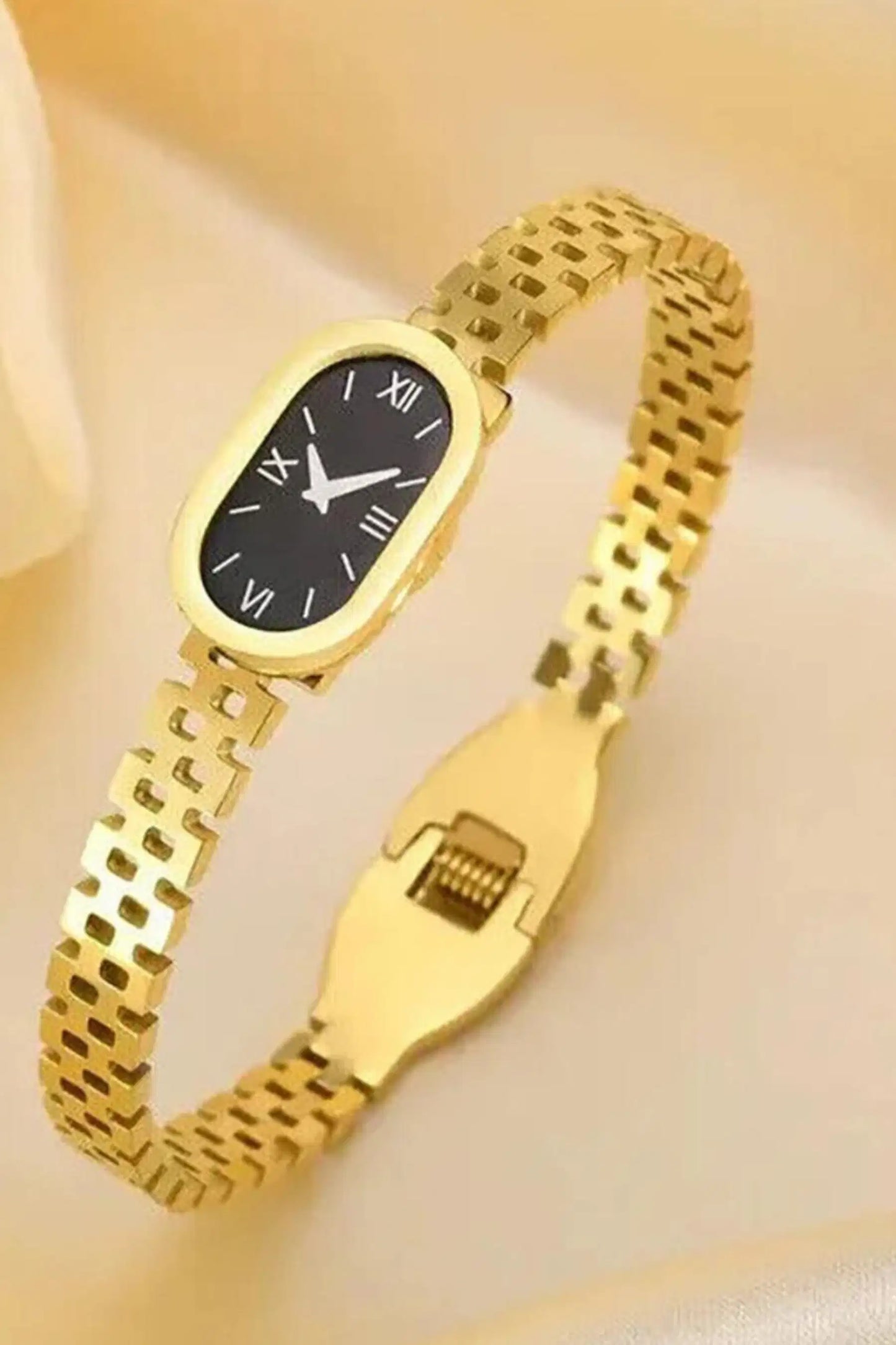 Gold wristwatch bracelet with black dial on a light yellow background